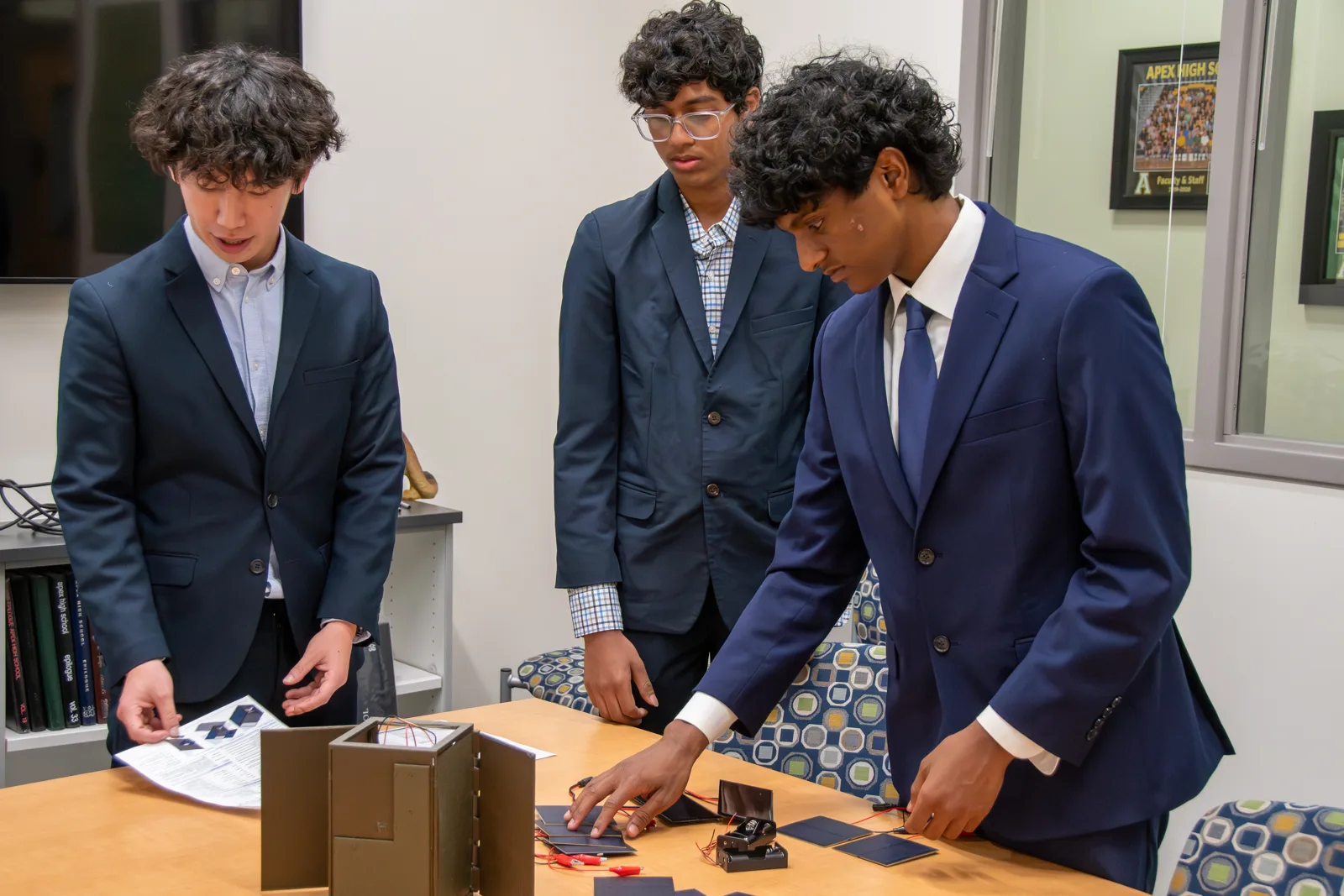Apex High seniors work on the AETHER-12 satellite prototype at the school.