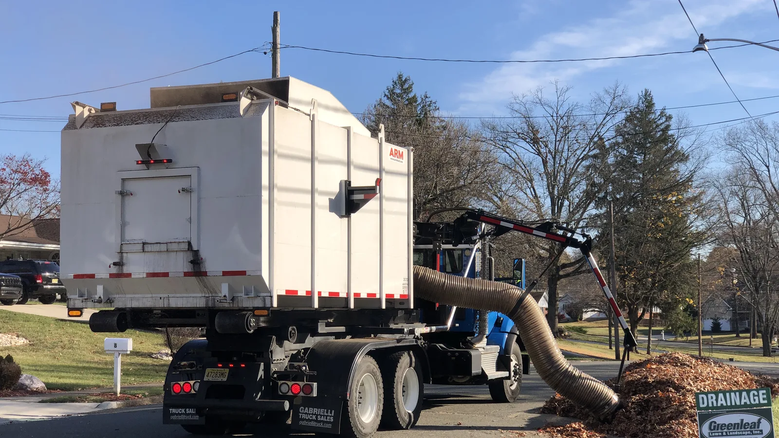 A leaf vacuum truck collects a curbside leaf pile in Ewing Township, New Jersey. Apex Public Works uses the same kind of truck.