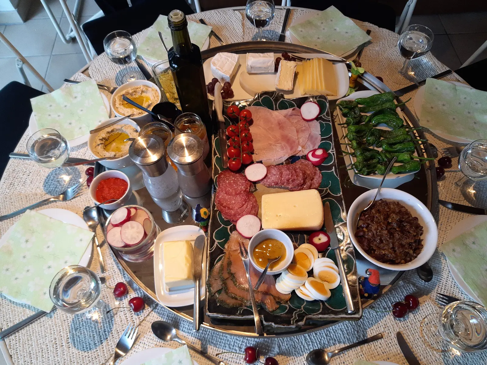 A brunch spread of cheeses, cold cuts, smoked salmon, eggs and peppers on a round table in Ehrenbach, Germany.