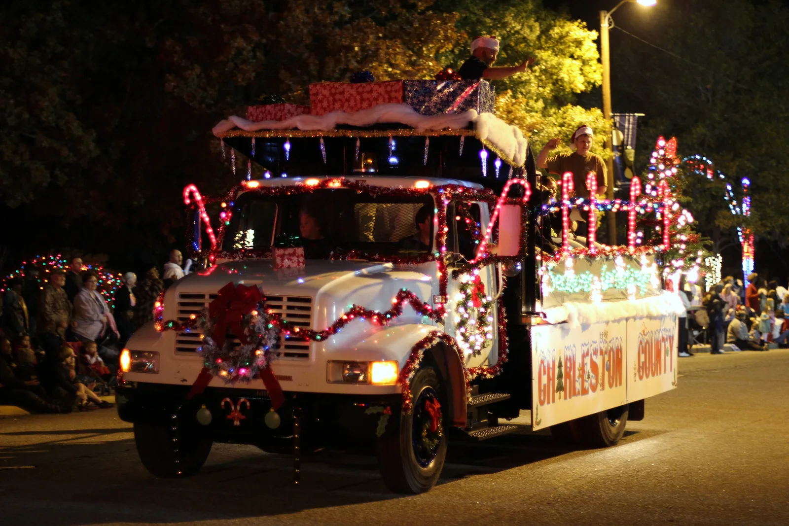 A float trimmed in lights rolls through a nighttime Christmas parade in North Charleston, South Carolina.