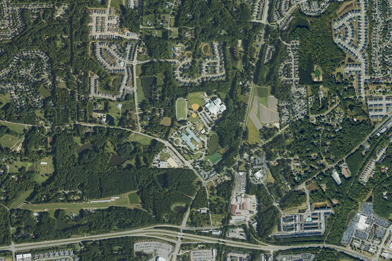 Aerial view of the Salem Elementary and Salem Middle school campus on Old Jenks Road and the subdivisions around it in September 2022, with US 64 along the bottom