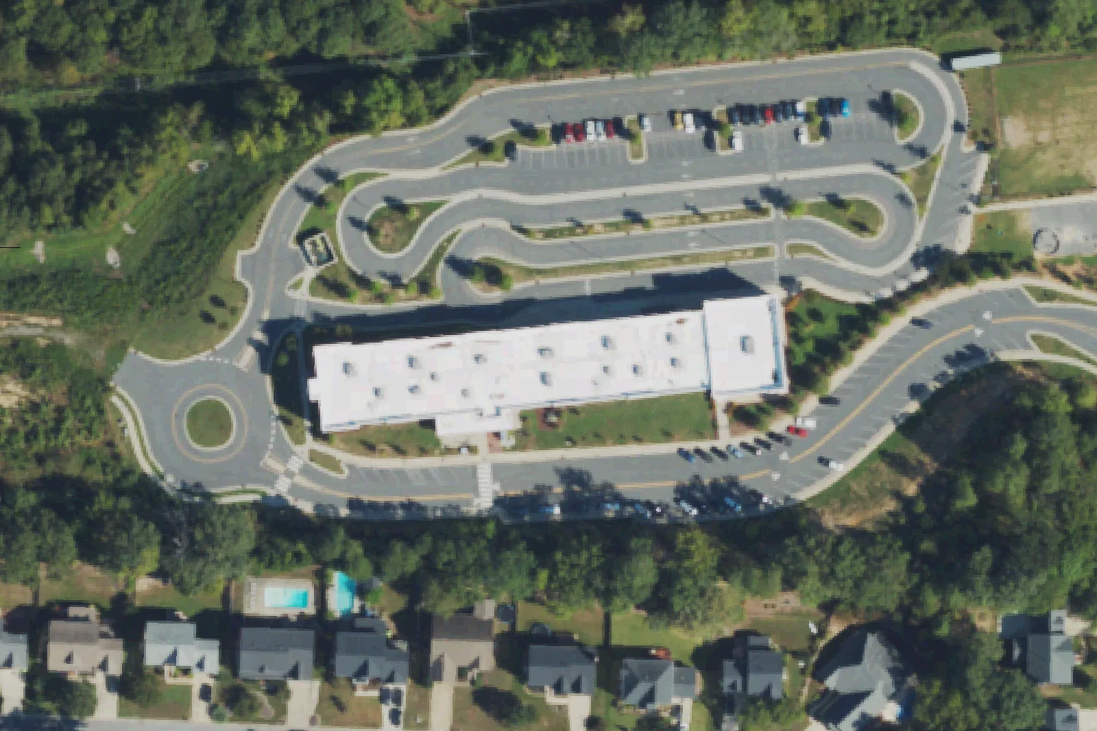 Peak Charter Academy's building and car line on Orchard Villas Avenue in Apex, seen from the air